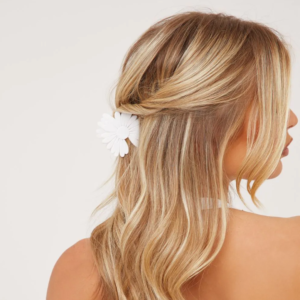view of back of lady's head with blonde hair clipped in a white flower claw clip