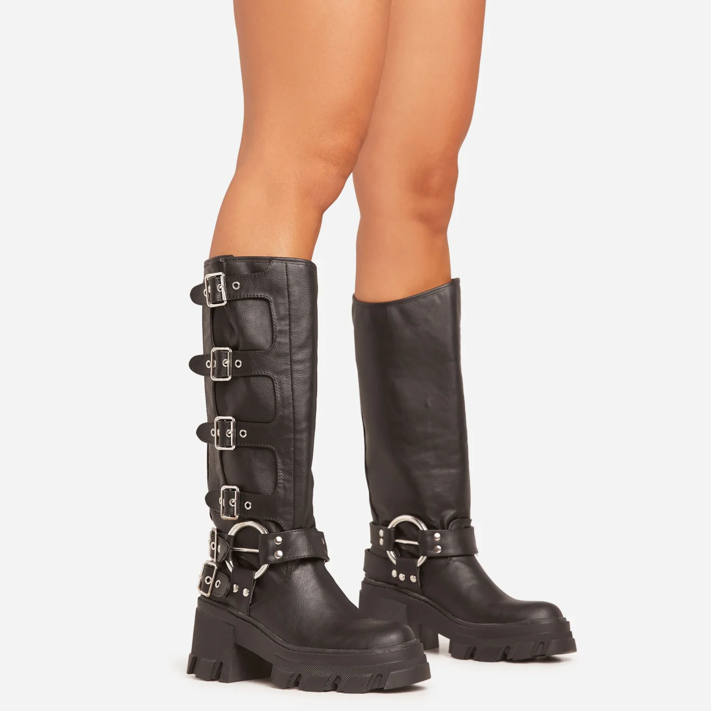 Black faux leather botts that go up to just below the knee. The botts have multiple have chunky soles, multiple side buckles and silver hardware.