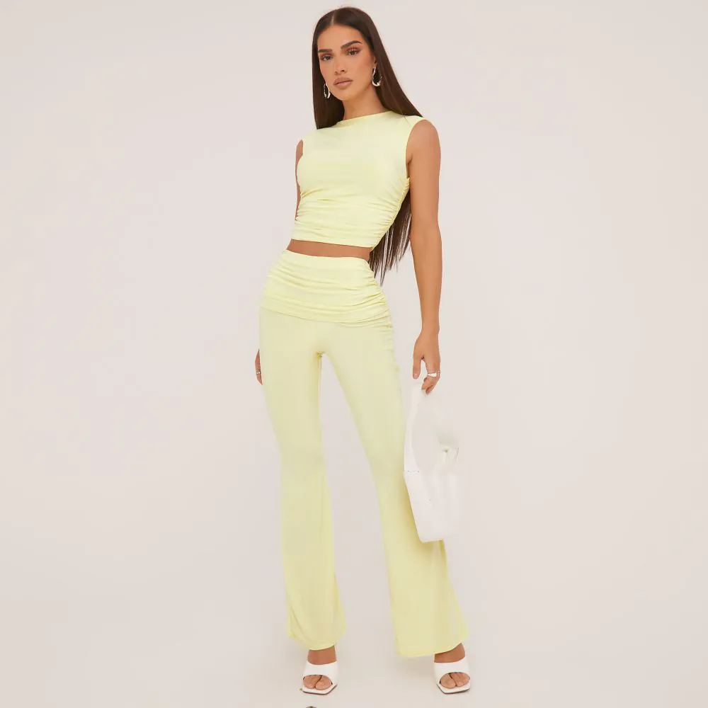 High Neck Sleeveless Top And Low Rise Fold Over Flared Trousers Co-Ord Set In Pastel Yellow Slinky